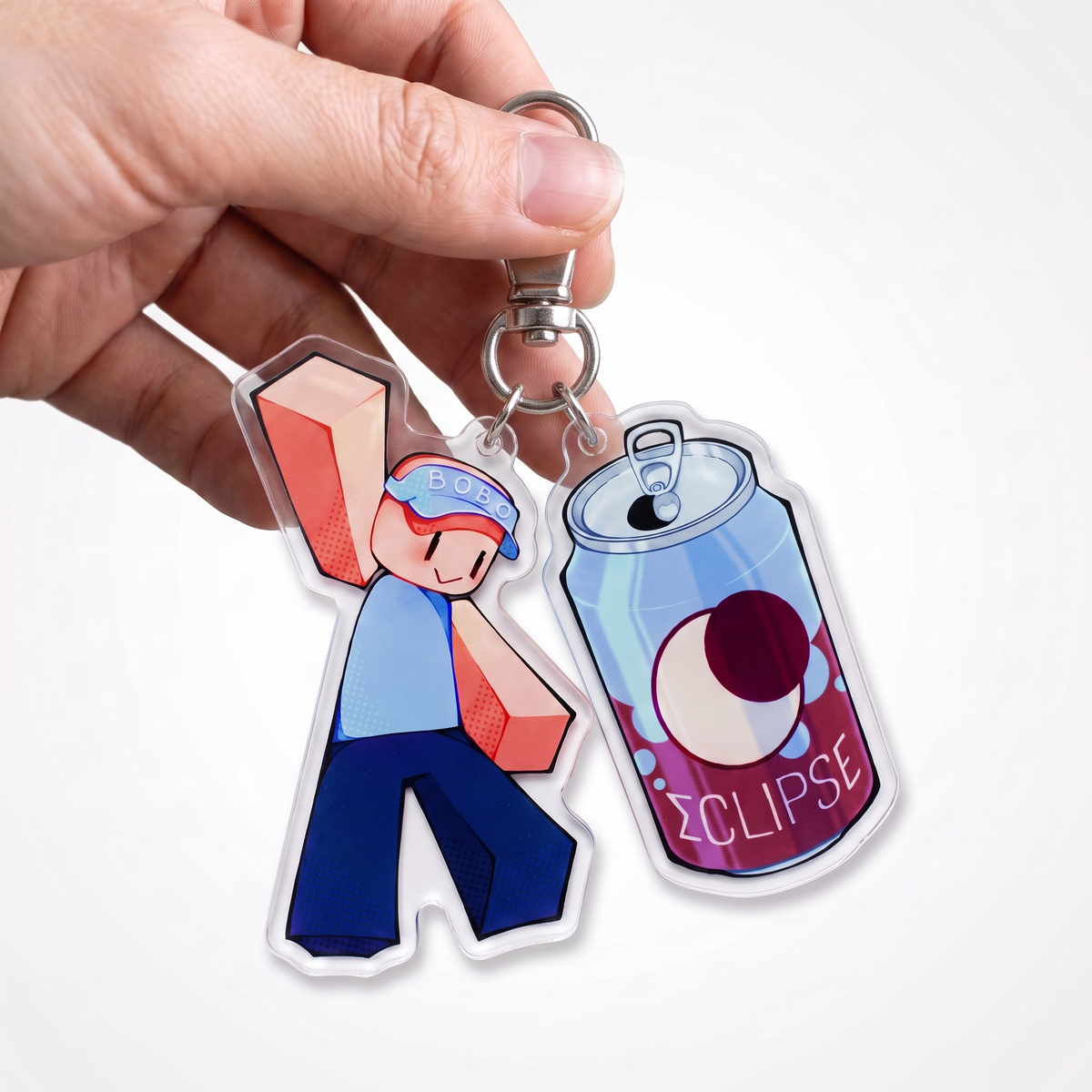 Hand holding the BOBO and Eclipse keychain set